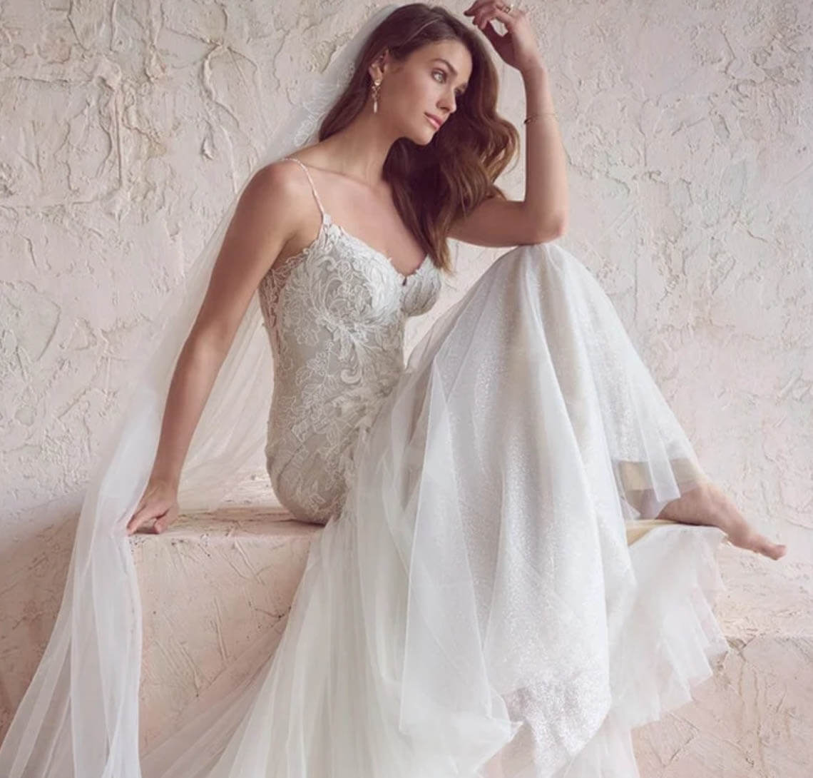 Model wearing a white gown by Maggie Sottero. Mobile image